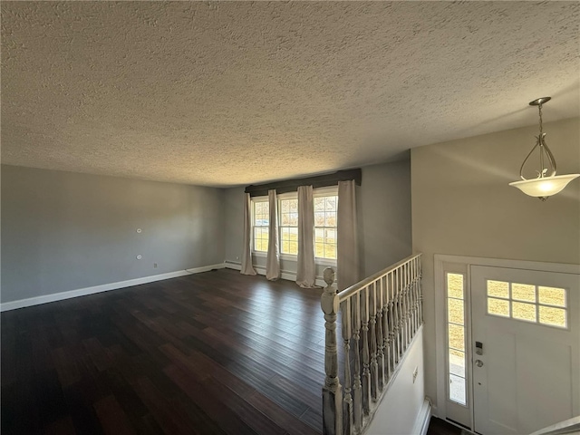 entryway featuring baseboards, dark wood-type flooring, and a textured ceiling