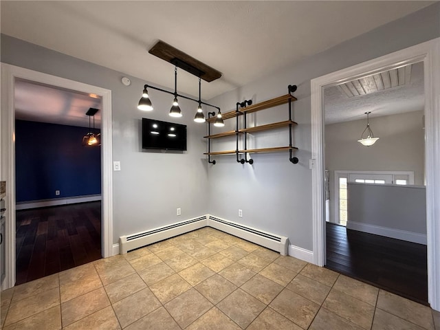 tiled foyer with a baseboard heating unit and baseboards