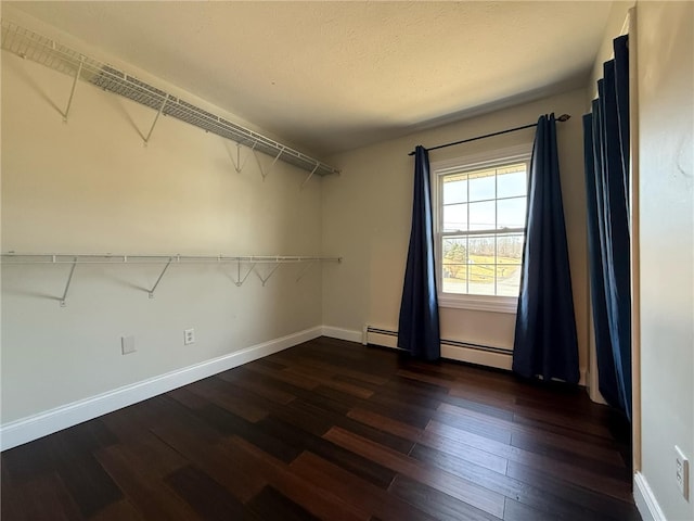 walk in closet featuring a baseboard radiator and dark wood-type flooring