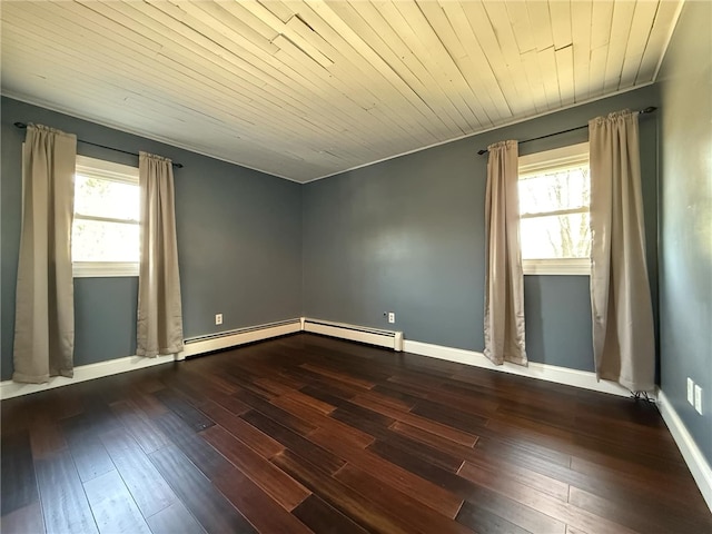 spare room featuring baseboard heating, baseboards, and wood-type flooring