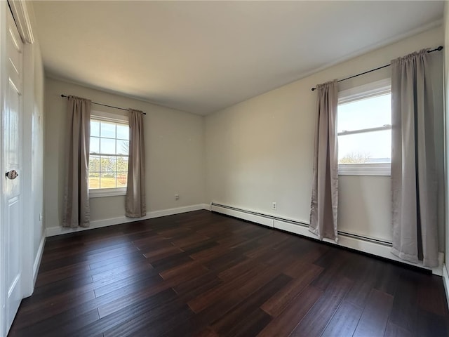 empty room with baseboard heating, dark wood-type flooring, and baseboards