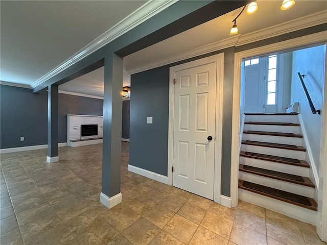 interior space featuring a brick fireplace, baseboards, and ornamental molding