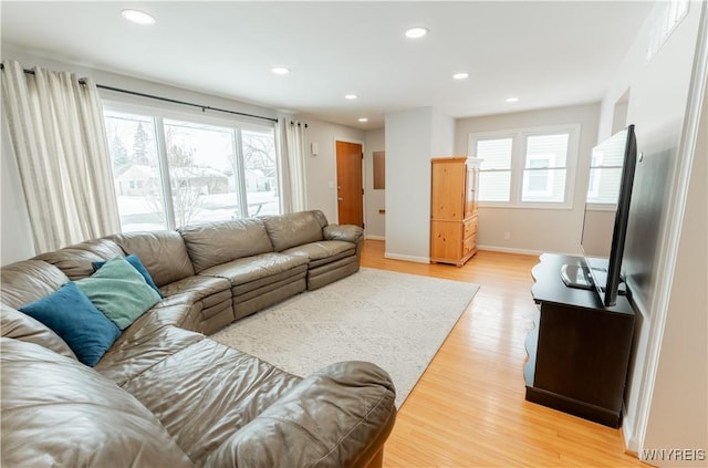 living room with light wood finished floors, recessed lighting, baseboards, and a wealth of natural light