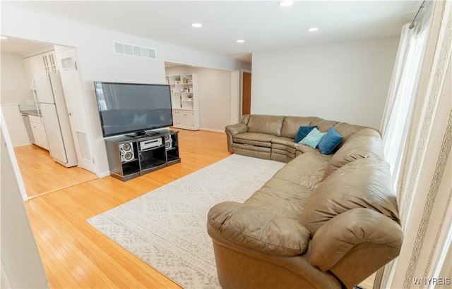 living room featuring recessed lighting, visible vents, and wood finished floors