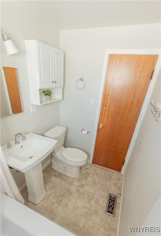 half bathroom with toilet, baseboards, and visible vents