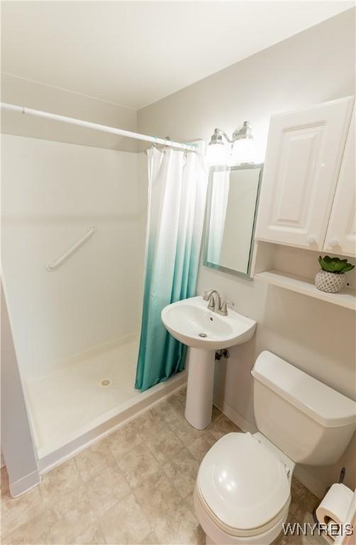 bathroom with toilet and a stall shower