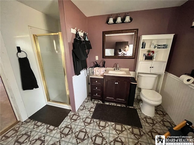 bathroom with toilet, a stall shower, vanity, and radiator heating unit