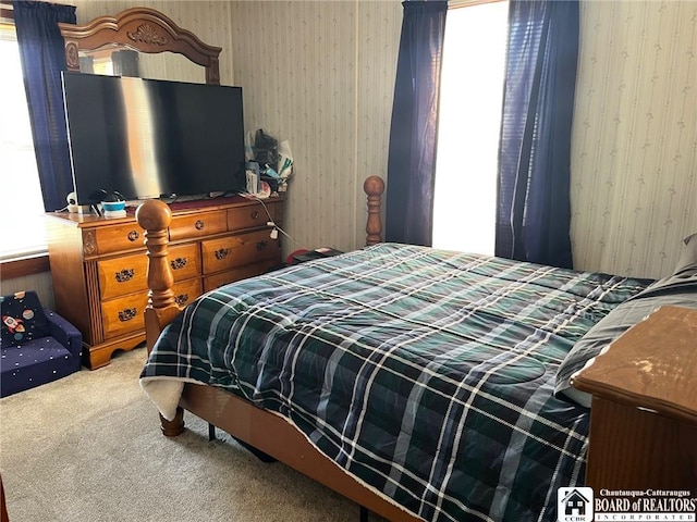 bedroom featuring wallpapered walls and carpet