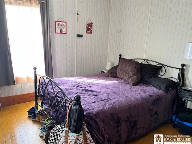 bedroom featuring hardwood / wood-style floors and wallpapered walls