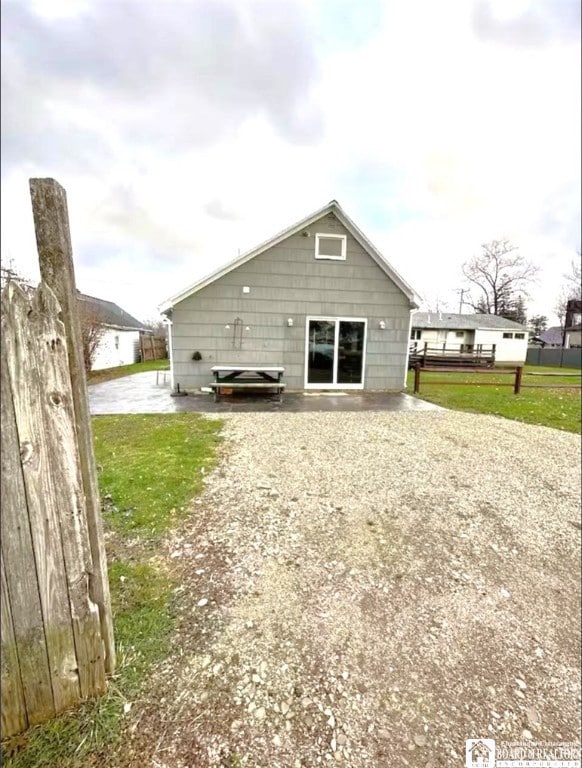 rear view of property with fence and driveway