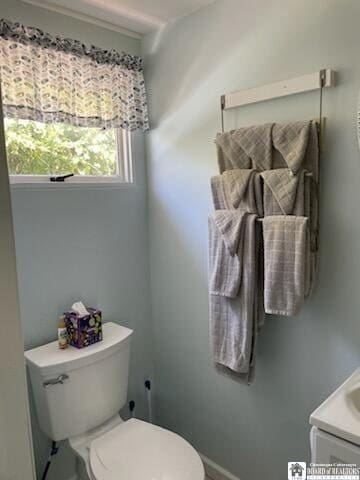 bathroom featuring baseboards, toilet, and vanity