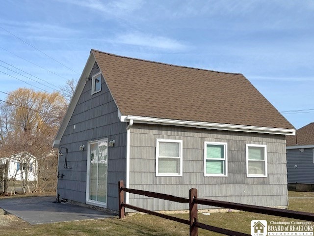 exterior space featuring a patio and roof with shingles