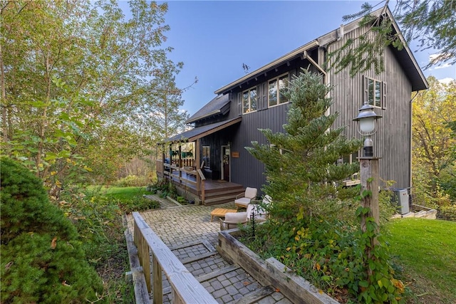 view of side of property featuring a patio, cooling unit, and a wooden deck