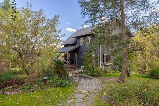 exterior space featuring a shingled roof and a wooden deck