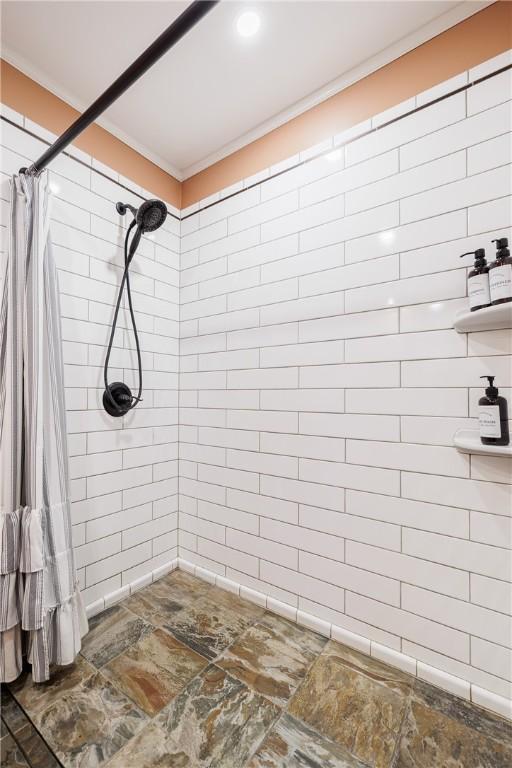 full bathroom with crown molding and a tile shower