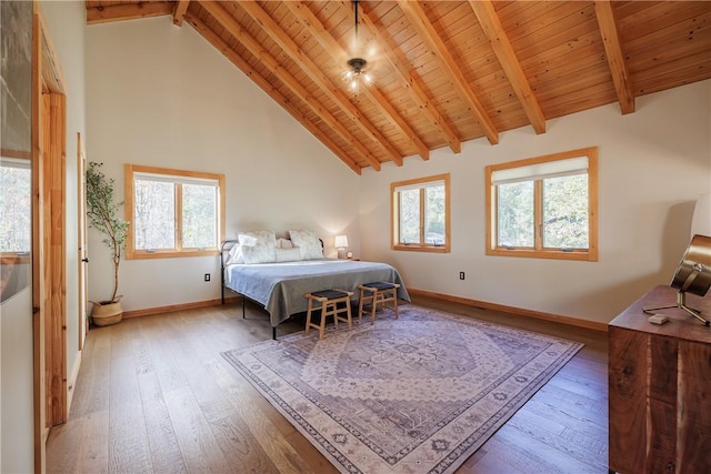 bedroom featuring baseboards, beamed ceiling, hardwood / wood-style floors, wooden ceiling, and high vaulted ceiling