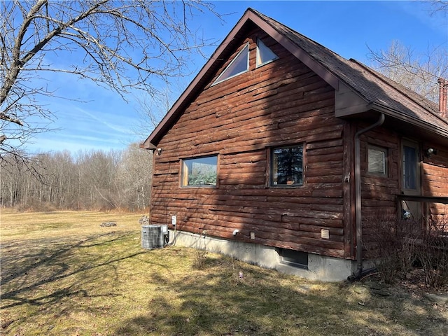 view of side of home featuring cooling unit and a lawn