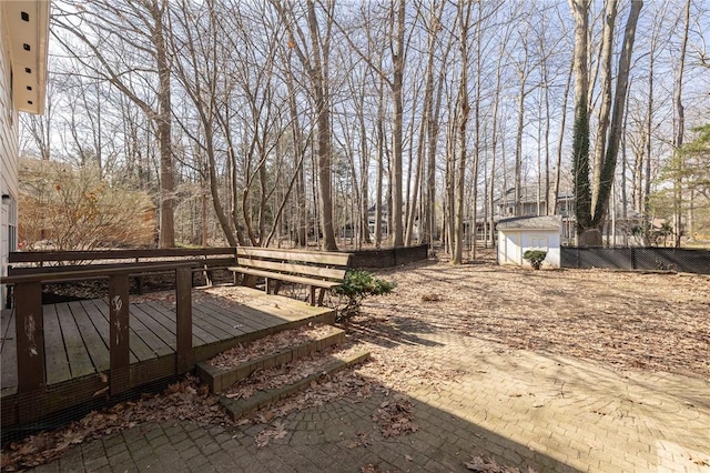 view of yard with a wooden deck, an outdoor structure, and fence