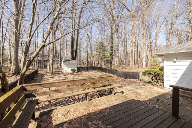 deck featuring an outbuilding, a shed, and fence