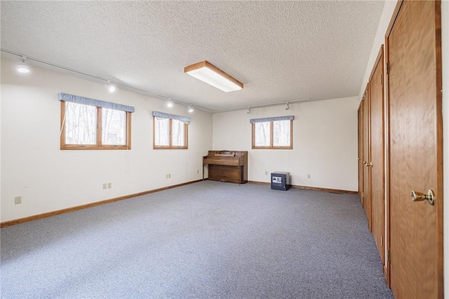 basement featuring baseboards, a textured ceiling, and carpet