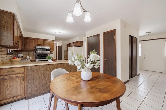 dining space with an inviting chandelier and light tile patterned flooring