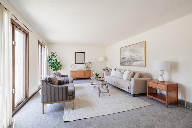 living area with plenty of natural light and carpet flooring