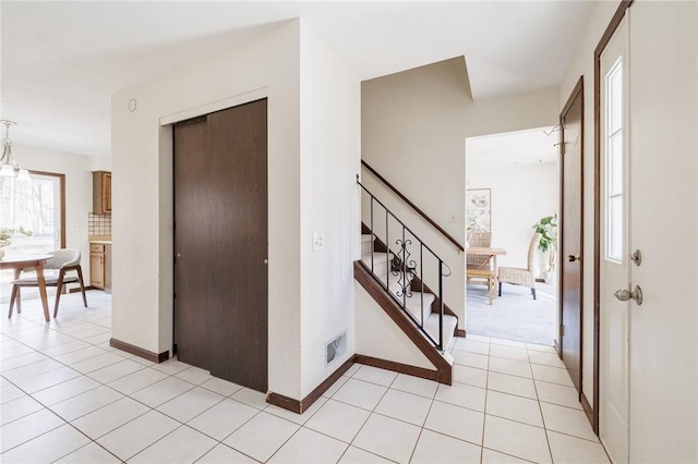 entrance foyer featuring stairs, light tile patterned flooring, baseboards, and visible vents