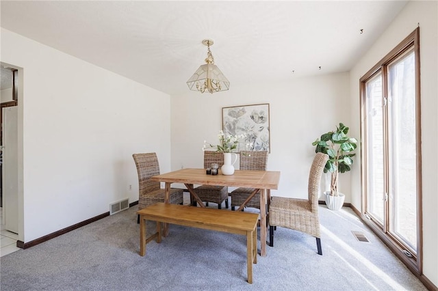 dining space featuring visible vents, light colored carpet, and baseboards