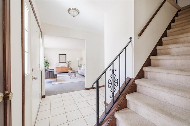 staircase featuring tile patterned floors, baseboards, and carpet floors