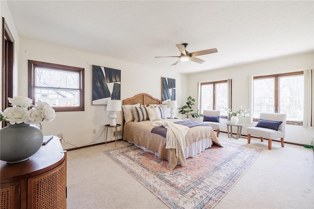 bedroom featuring light colored carpet, baseboards, and ceiling fan