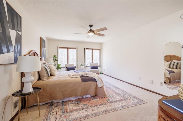 carpeted bedroom with a ceiling fan and baseboards