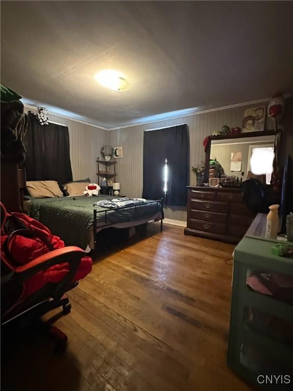 bedroom with hardwood / wood-style flooring and crown molding