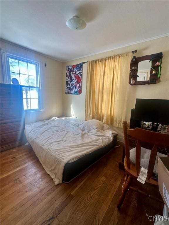 bedroom with hardwood / wood-style flooring and ornamental molding