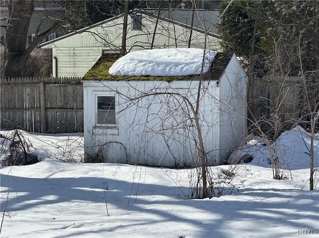 snow covered structure with fence