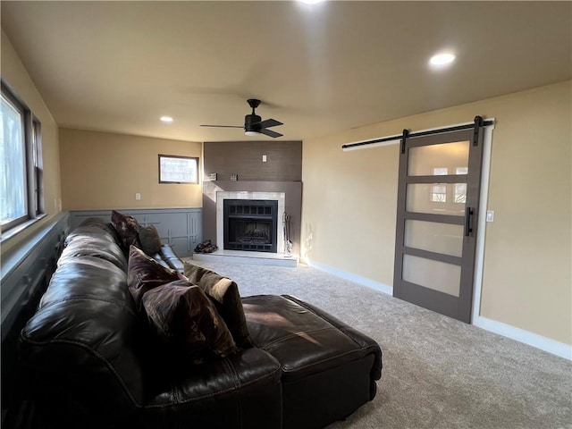 living area with ceiling fan, baseboards, a barn door, and carpet floors