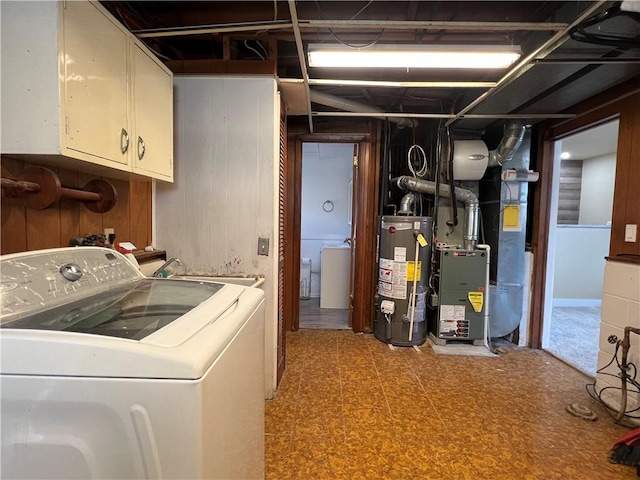 washroom with a sink, washer / clothes dryer, water heater, cabinet space, and light floors