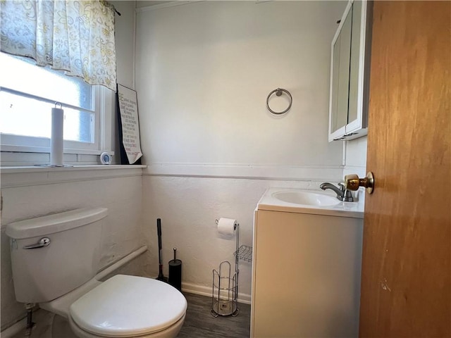 bathroom featuring vanity, toilet, wood finished floors, and baseboards