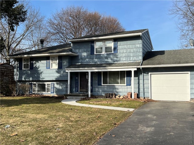 split level home featuring a front lawn, an attached garage, and driveway