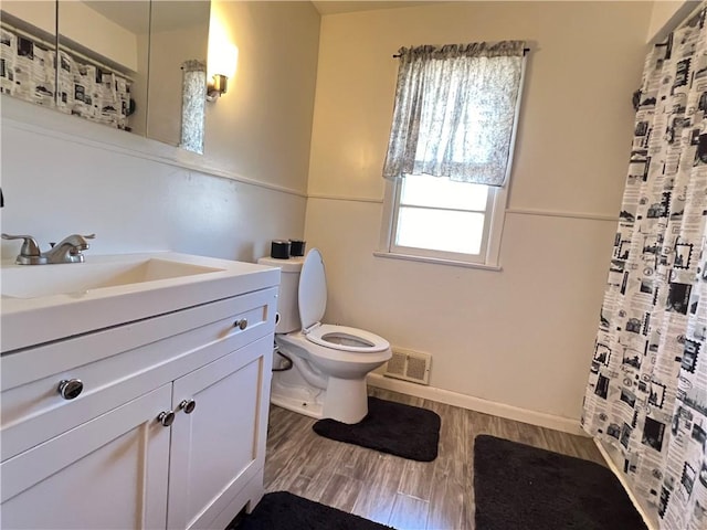 bathroom with visible vents, curtained shower, toilet, wood finished floors, and vanity