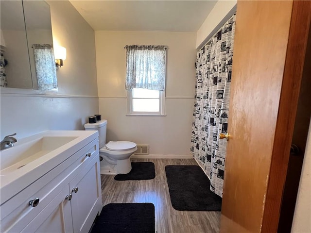 bathroom featuring vanity, a shower with curtain, wood finished floors, visible vents, and toilet