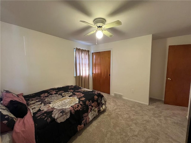 carpeted bedroom with visible vents, baseboards, a closet, and ceiling fan