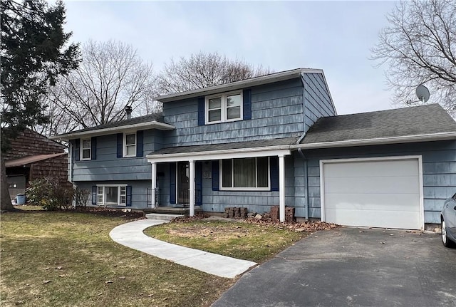 split level home featuring aphalt driveway, an attached garage, a shingled roof, and a front yard