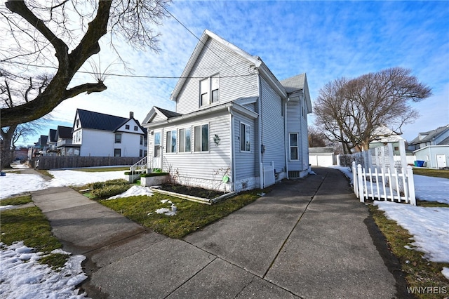 view of home's exterior featuring a garage, a residential view, and fence