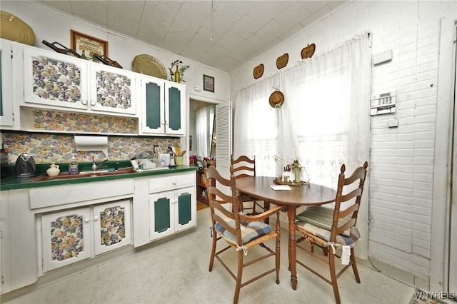 dining room featuring brick wall