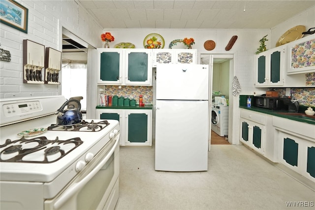 kitchen with dark countertops, backsplash, glass insert cabinets, white appliances, and washer / clothes dryer