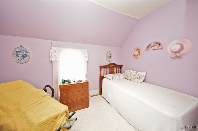 bedroom with light colored carpet and vaulted ceiling