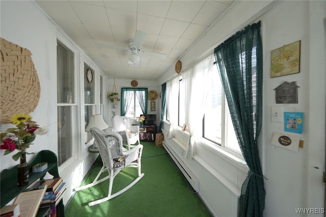 sunroom / solarium with ceiling fan and a baseboard radiator