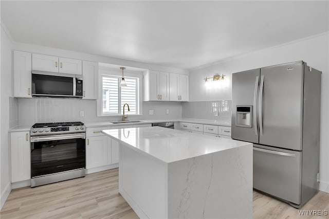 kitchen with white cabinetry, stainless steel appliances, and a sink