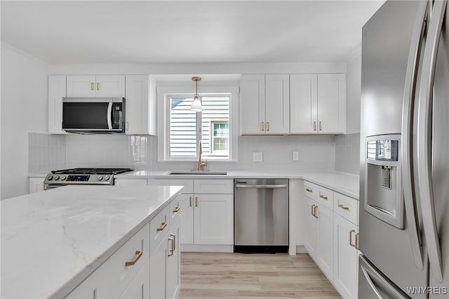 kitchen featuring decorative backsplash, white cabinets, light wood-style flooring, and appliances with stainless steel finishes