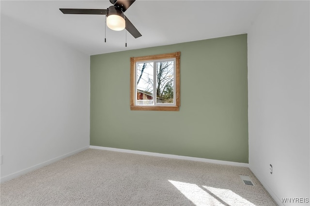 unfurnished room with visible vents, carpet floors, baseboards, and ceiling fan